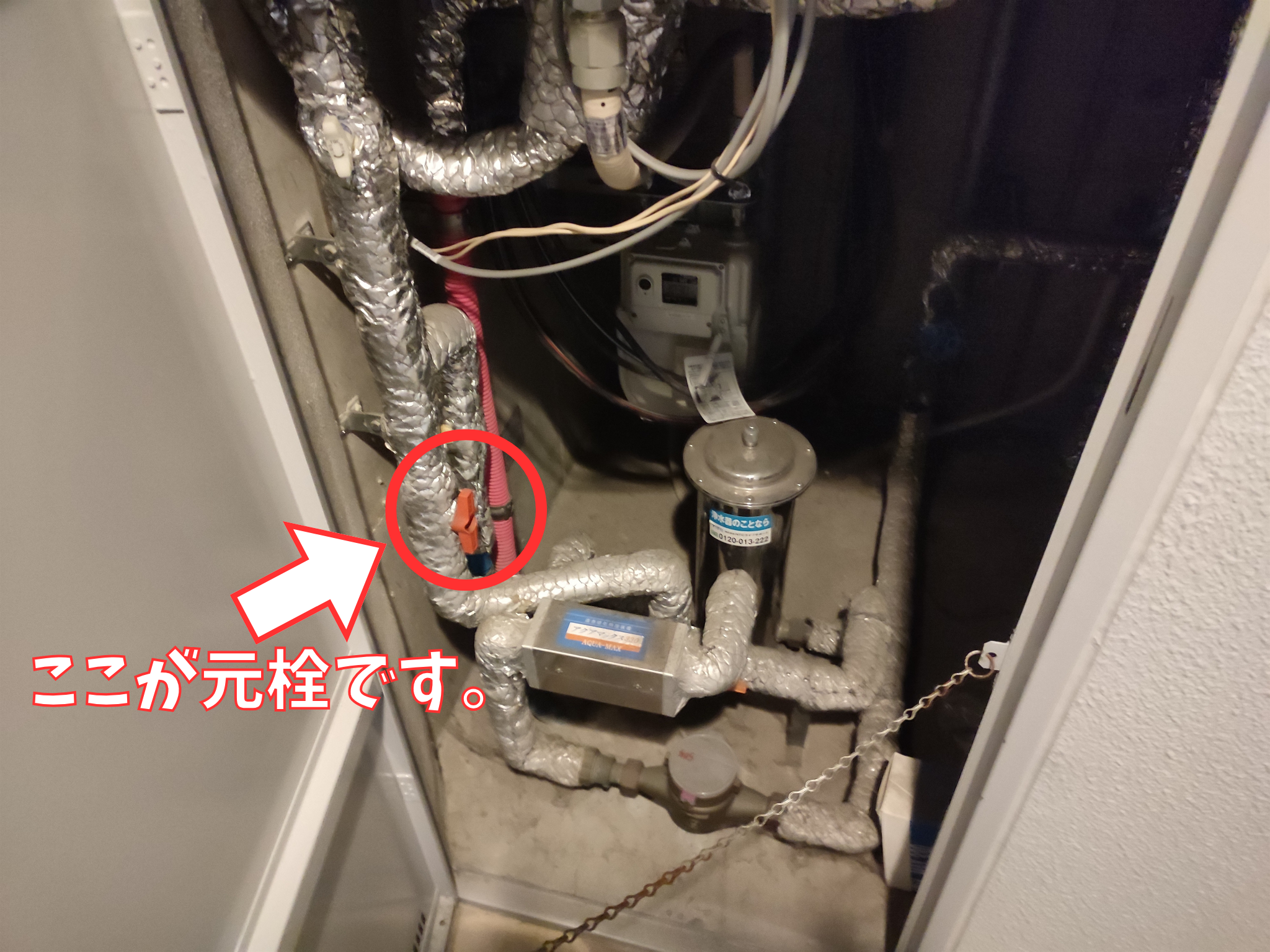 マンションのメーターボックス内にある大元のガスの元栓(赤いレバー)を矢印と文字で指し示している解説写真